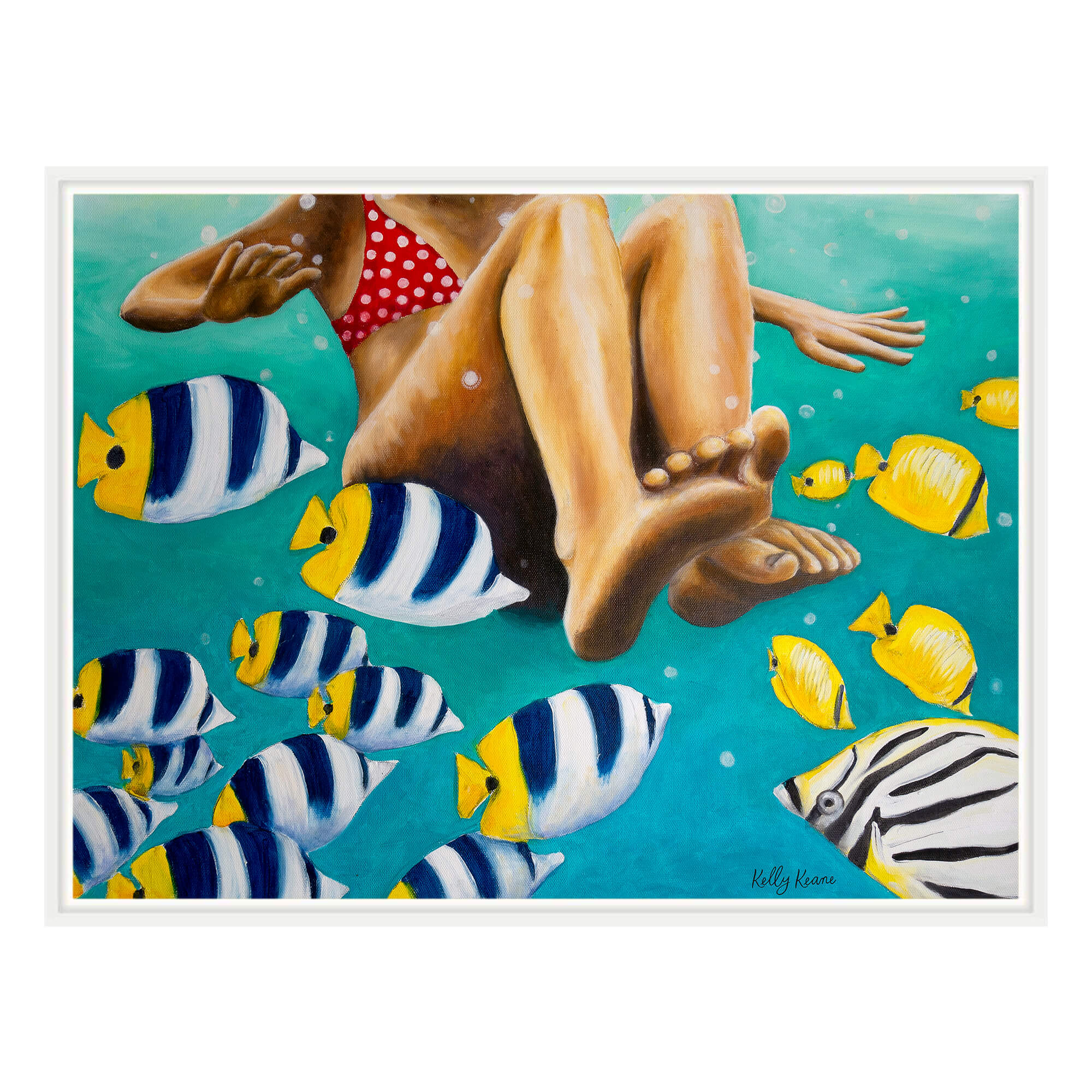A Canvas art print with white frame showcasing a woman swimming with fishes by hawaii artist Kelly Keane