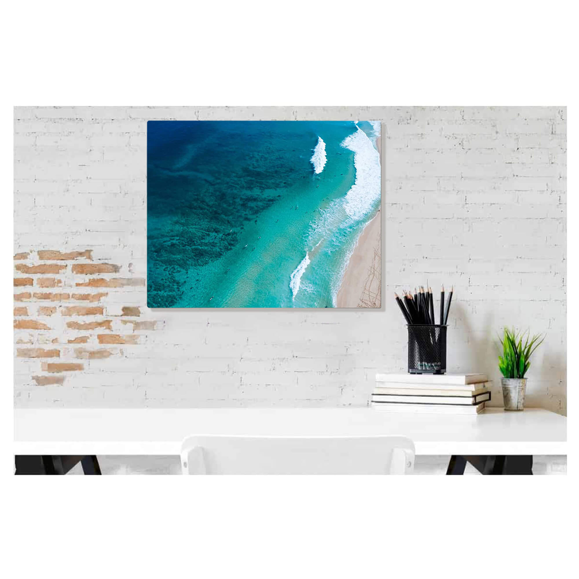 A metal art print of a dramatic aerial seascape print depicts a drone photo of famous waves and surfers near Pupukea by Hawaii artist Bree Poort