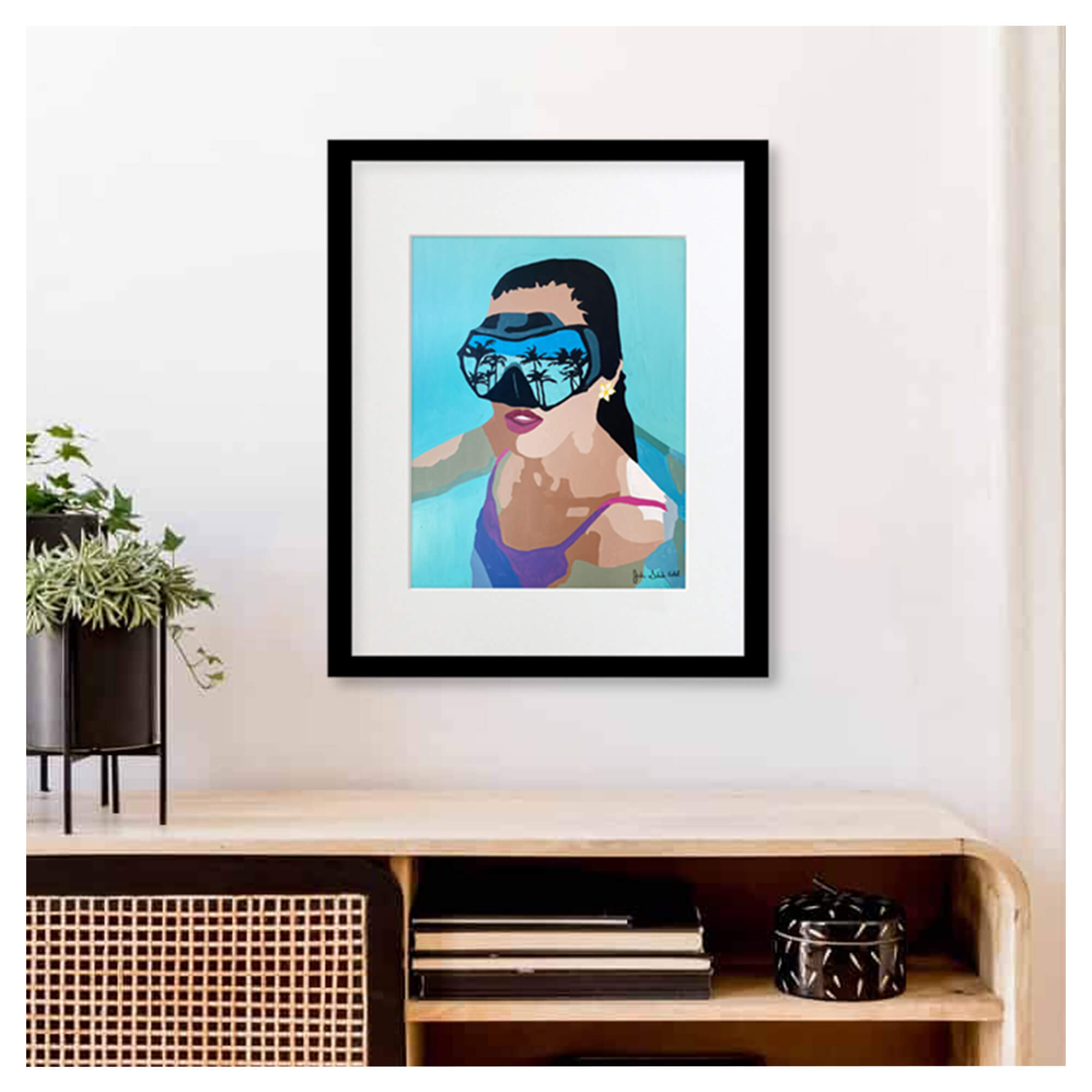 A framed matted art print featuring a portrait of a woman wearing goggles reflecting the tropical trees by Hawaii artist Jackie Eitel