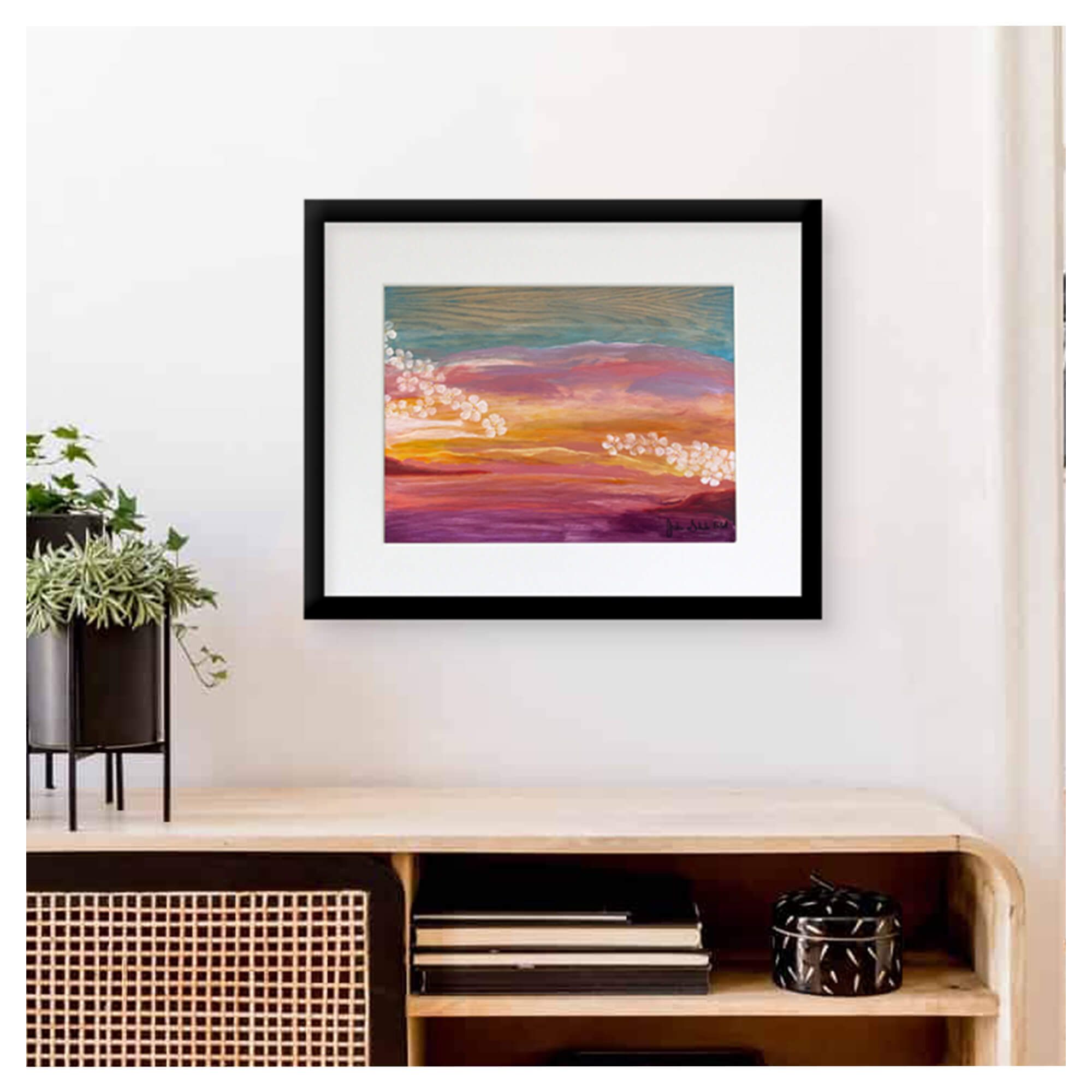 A framed matted art print featuring a vibrant colorful sunset and plumeria flowers by Hawaii artist Jackie Eitel