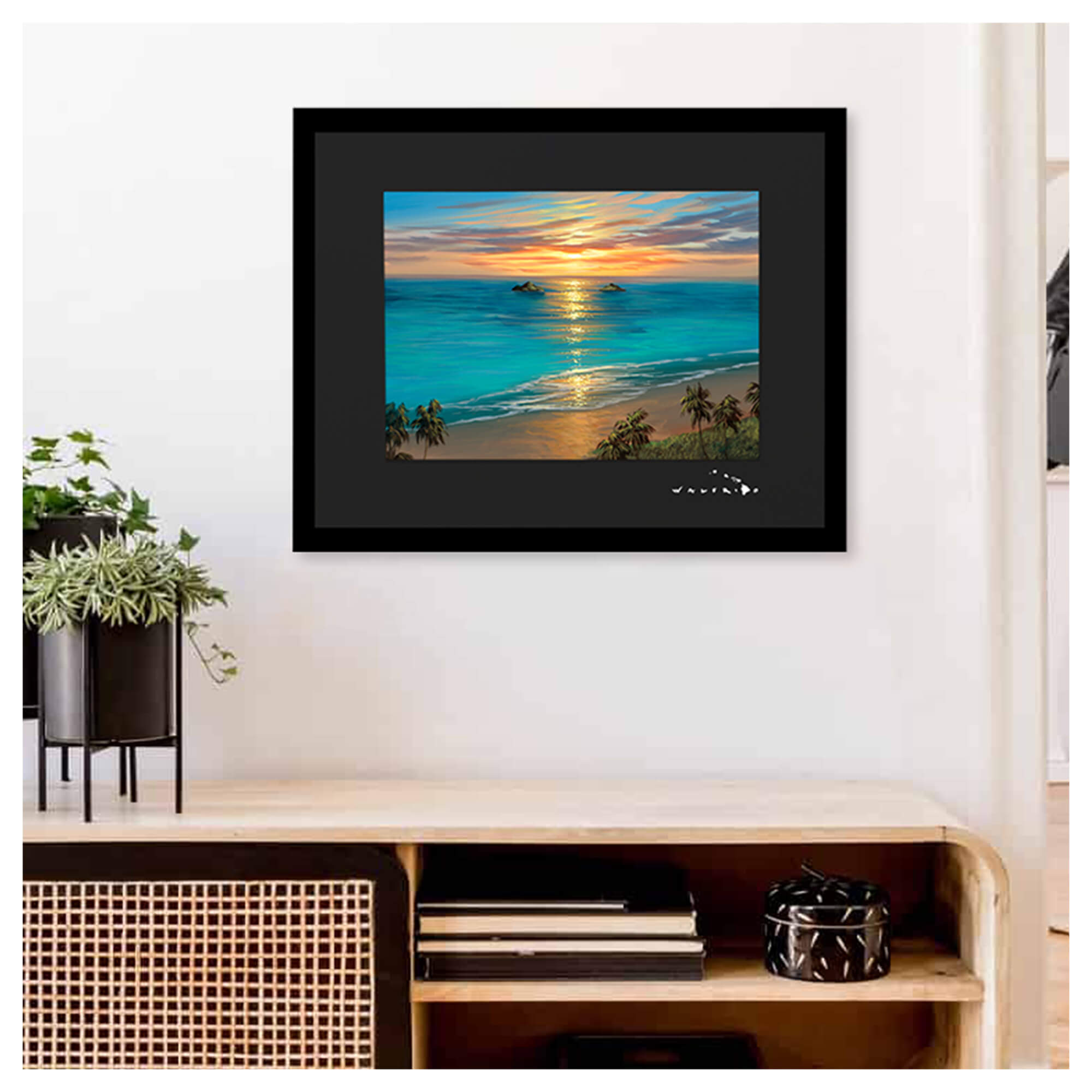A framed matted art print depicting the sun rising behind the Mokolua Islands just off the coast of eastern Oahu's Lanikai Beach by Hawaii artist Walfrido Garcia